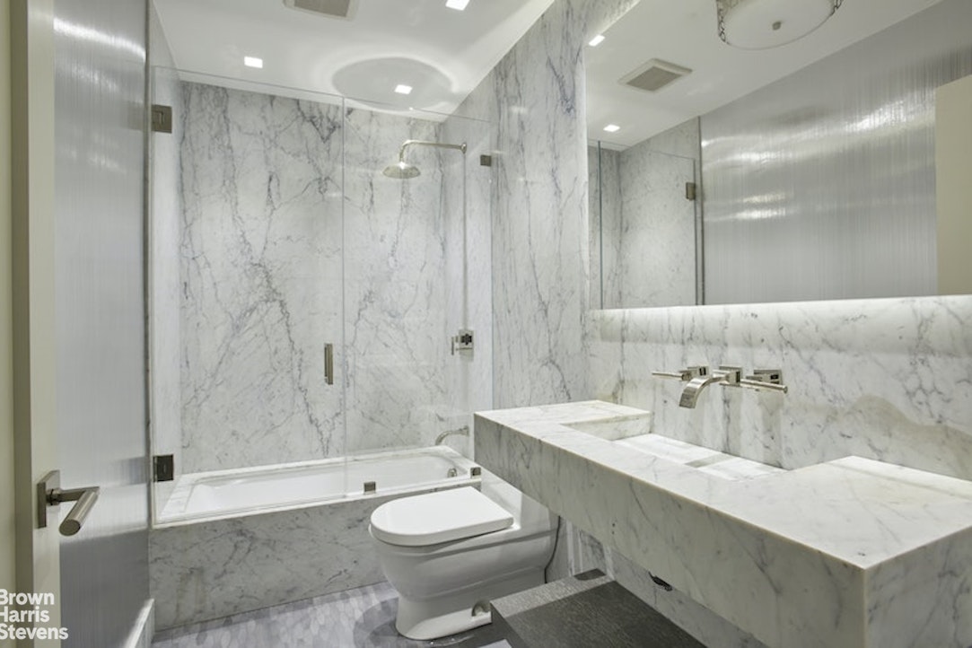 525 East 80th Street, Unit 7BC Manhattan, NY 10075 - Photo 9 of 13 a bathroom with a sink a toilet a mirror and shower