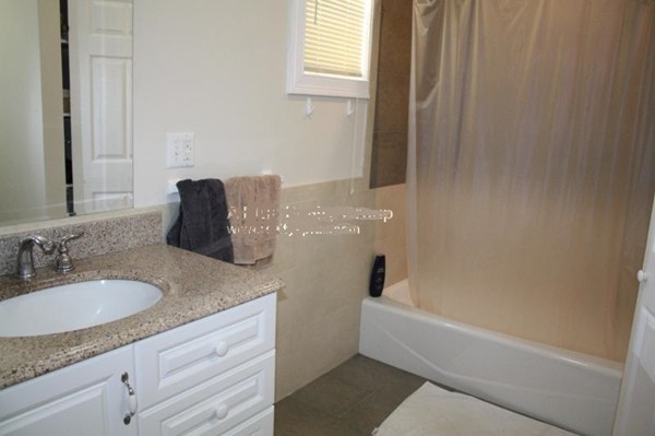 14 Schiller Street, Unit 2 Boston, MA 02130 - Photo 3 of 12 a bathroom with a granite countertop sink and a bathtub