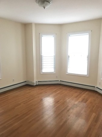 14 Schiller Street, Unit 2 Boston, MA 02130 - Photo 4 of 12 an empty room with wooden floor and windows