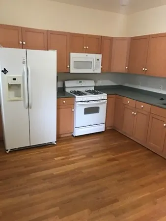 a kitchen with granite countertop a stove and a refrigerator