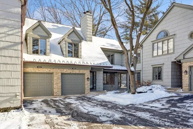 a front view of a house with a yard covered in snow