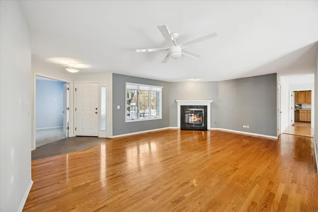 a view of an empty room with window and wooden floor