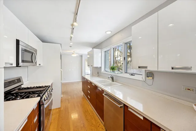 a kitchen with stainless steel appliances a sink stove and cabinets