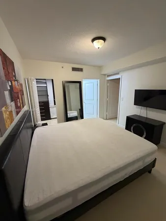 a bed sitting in a bedroom next to a cabinet