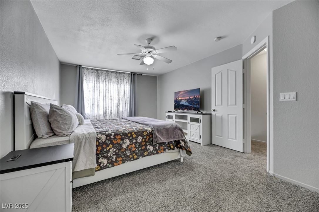 2907 Rio Sonora Court Henderson, NV 89074 - Photo 16 of 35 Bedroom with a textured wall, light carpet, a ceiling fan, and a textured ceiling