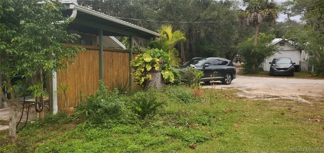 a view of a chair and table in backyard of the house