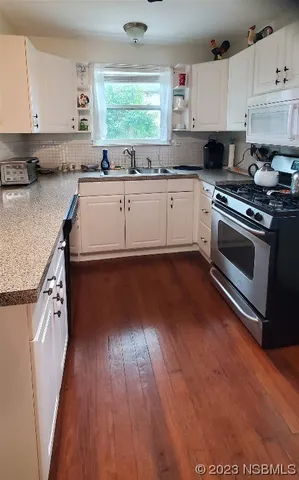 a kitchen with a sink a stove and cabinets
