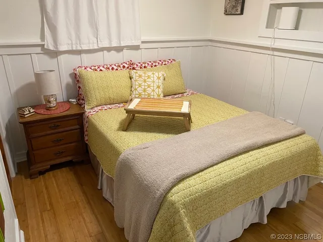 a bedroom with a bed and wooden floor