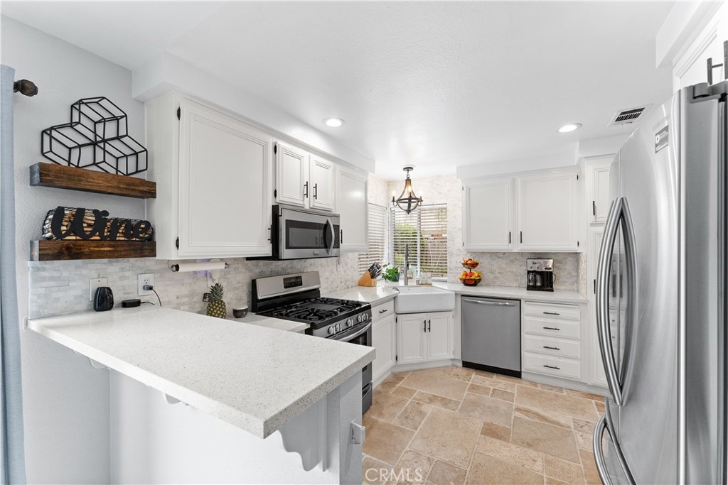 853 Cheyenne Road Corona, CA 92878 - Photo 3 of 8 a kitchen with stainless steel appliances a refrigerator sink and white cabinets