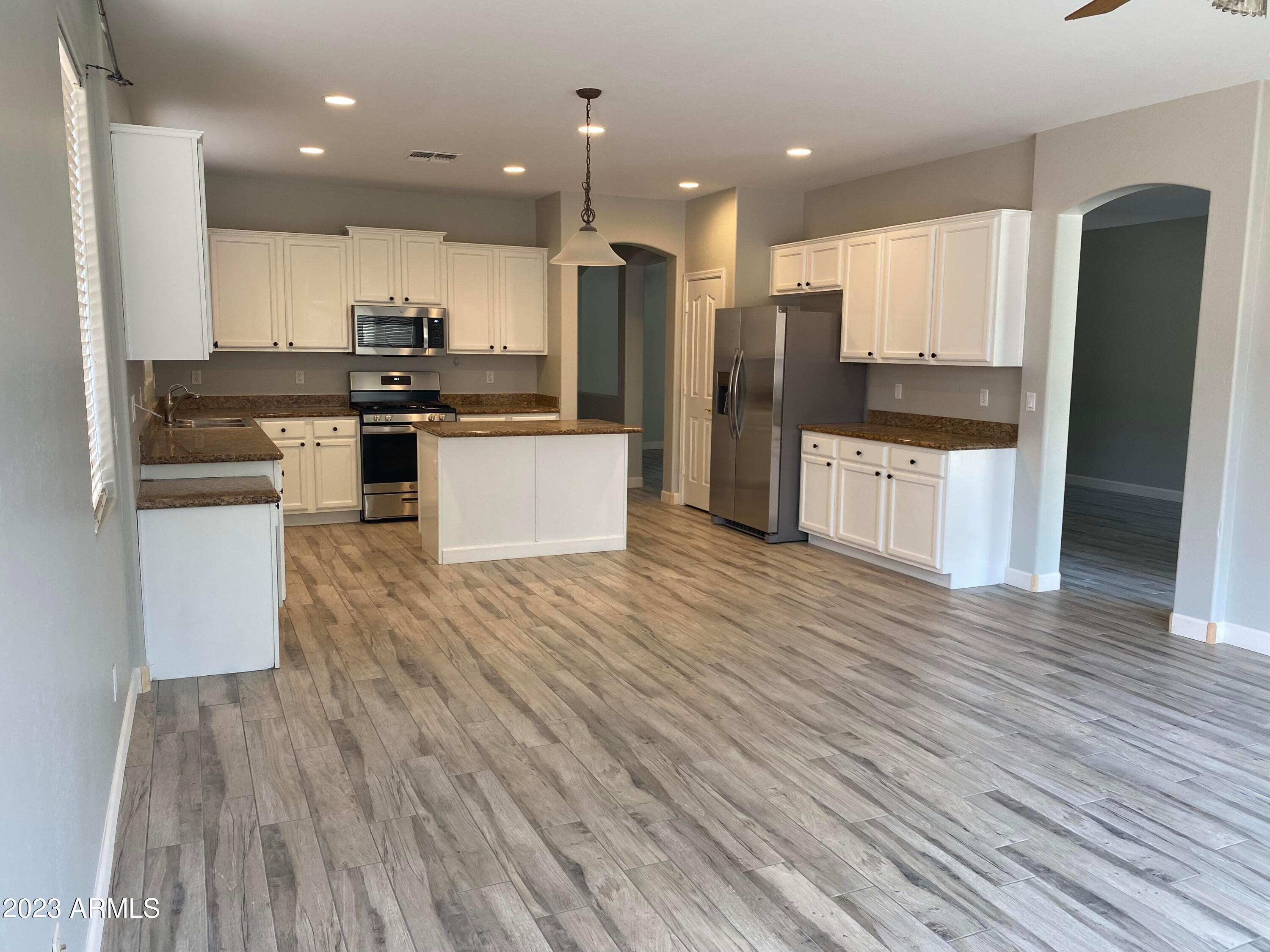 232 West Hawk Way Chandler, AZ 85286 - Photo 2 of 16 a kitchen with stainless steel appliances kitchen island granite countertop a refrigerator and a stove top oven