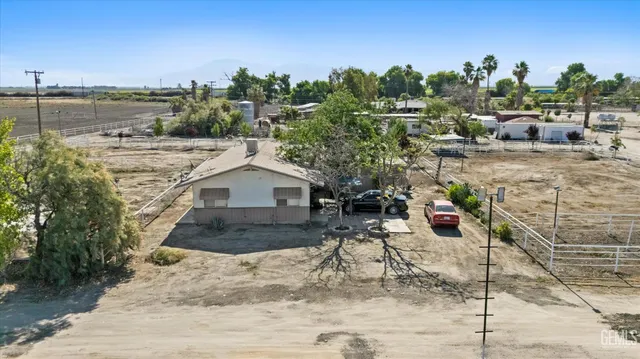 a view of a house with outdoor seating and trees in the background