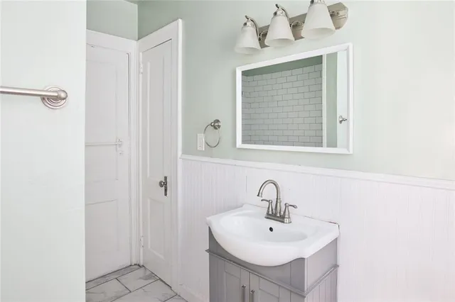 a kitchen with a sink a refrigerator a stove and white cabinets with wooden floor