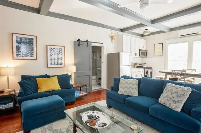 a living room with furniture wooden floor and a large window