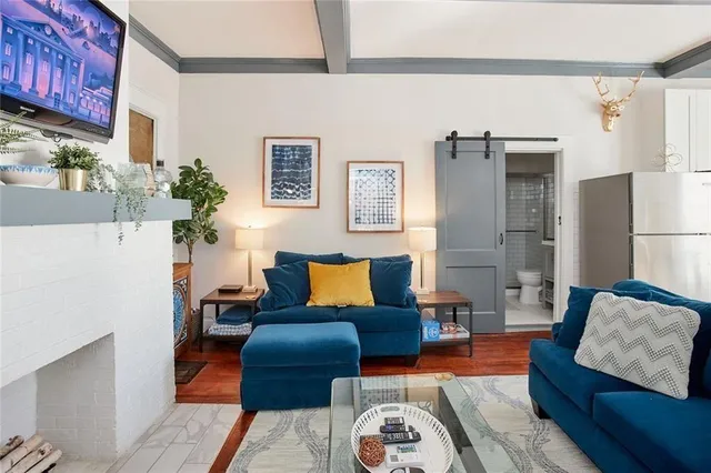 a kitchen with stainless steel appliances kitchen island granite countertop a refrigerator a stove a sink and white cabinets with wooden floor