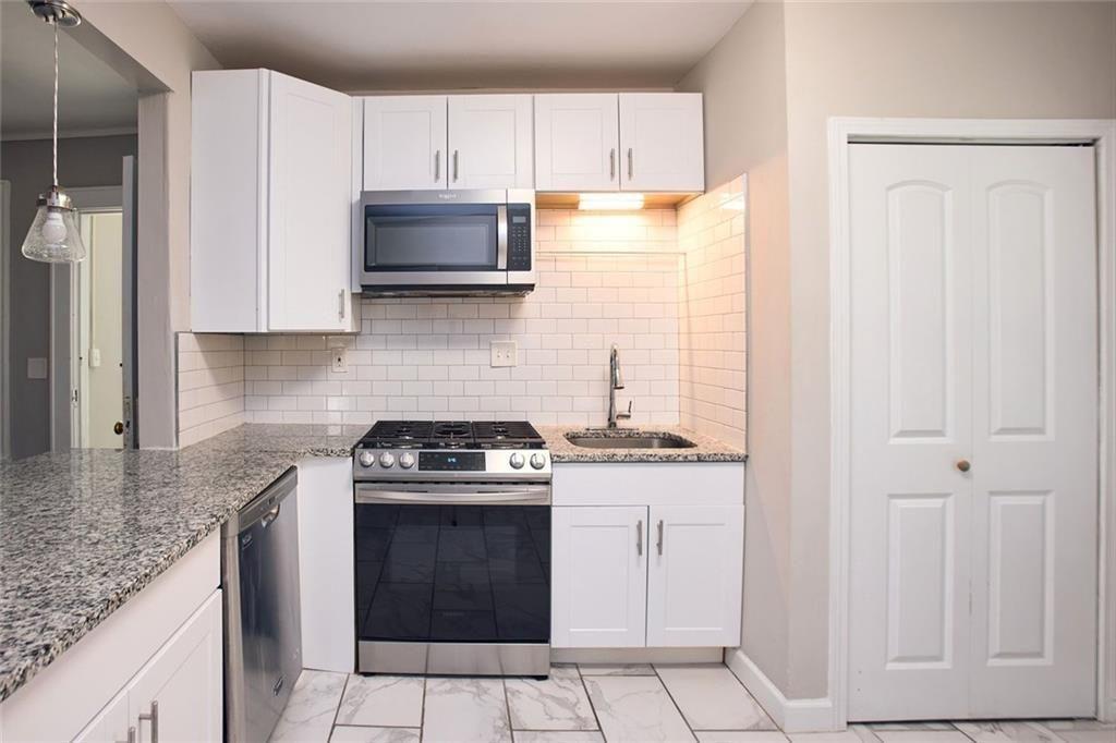 887 Myrtle Street Northeast Atlanta, GA 30309 - Photo 8 of 27 a kitchen with granite countertop a stove sink and cabinets