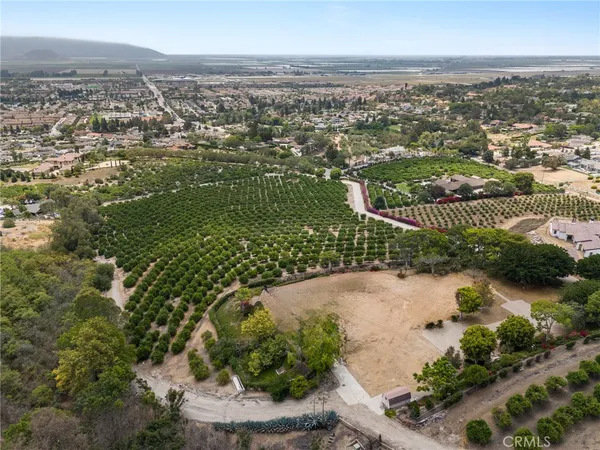 an aerial view of residential houses with outdoor space and trees