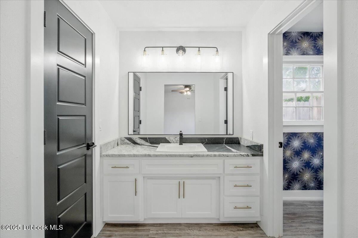 4214 64th Street Lubbock, TX 79413 - Photo 18 of 32 a bathroom with a granite countertop sink vanity and mirror