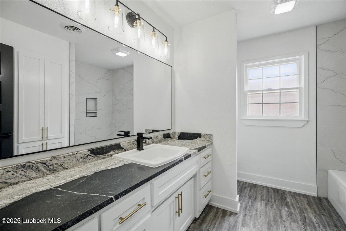 4214 64th Street Lubbock, TX 79413 - Photo 26 of 32 a bathroom with a sink and a mirror