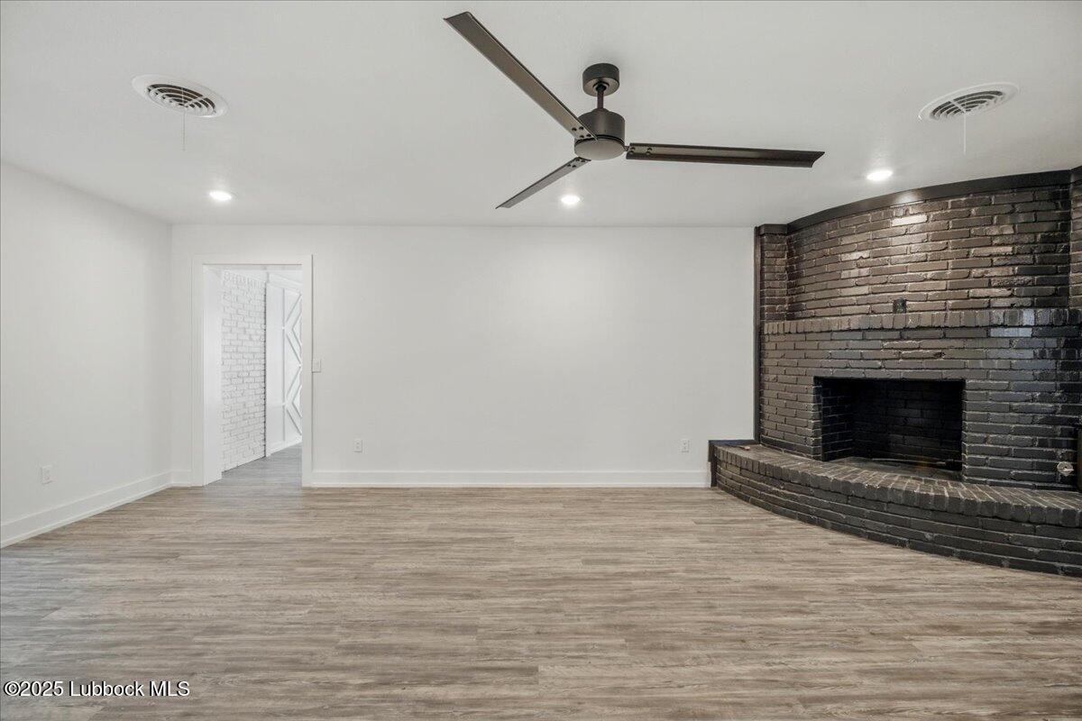 4214 64th Street Lubbock, TX 79413 - Photo 5 of 32 a view of an empty room with wooden floor fireplace and a window
