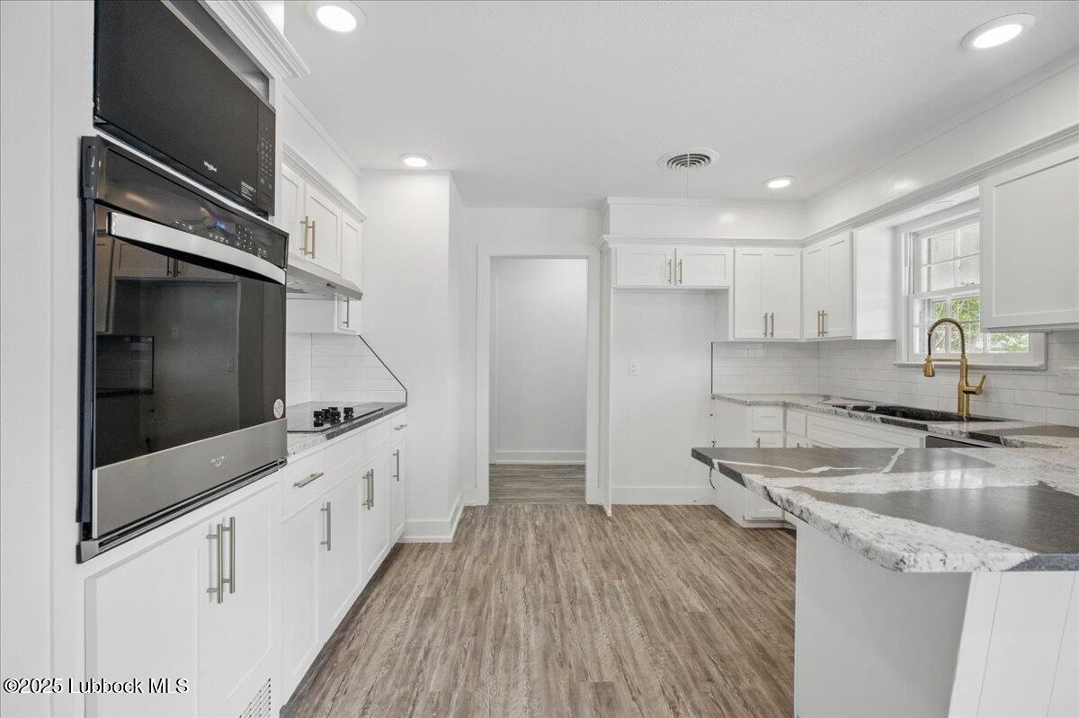 4214 64th Street Lubbock, TX 79413 - Photo 7 of 32 a kitchen with granite countertop a sink and refrigerator