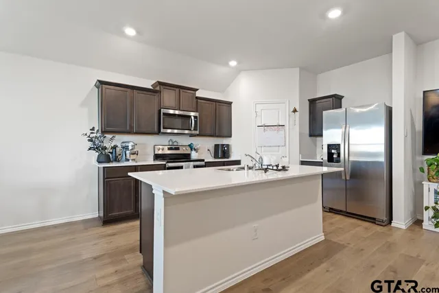 a kitchen with stainless steel appliances a refrigerator stove microwave and sink