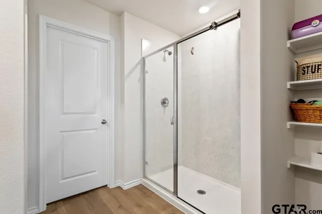a bathroom with a shower and a glass door