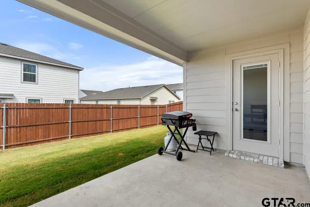 a view of a backyard with plants and table in the patio