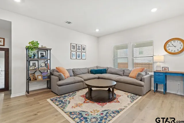 a living room with furniture a rug and wall paintings