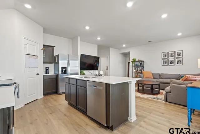 a kitchen with kitchen island a sink a counter top space stainless steel appliances and cabinets