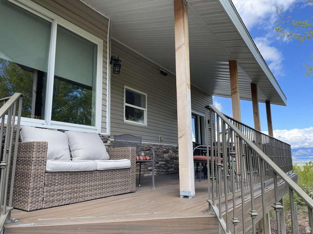 7030 West 2100 North Mendon, UT 84325 - Photo 51 of 67 Expansive outdoor deck featuring wood-finish flooring, robust wooden support columns, and decorative metal railings