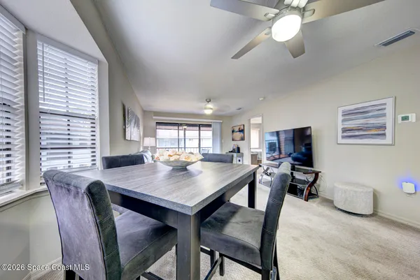 a view of a dining room with furniture and a large window