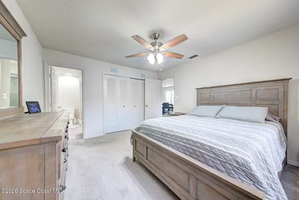a spacious bedroom with a bed and a chandelier