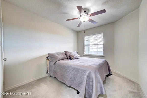 a bedroom with a large bed chandelier and a window