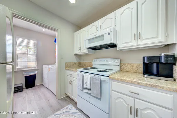 a kitchen with cabinets appliances a sink and a window