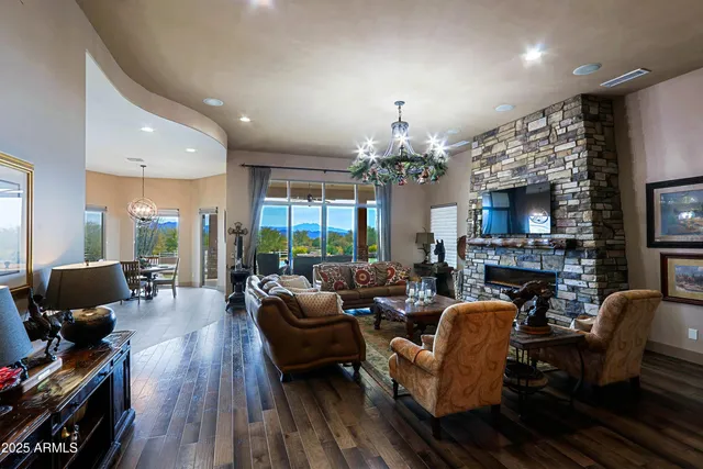 a living room with furniture a chandelier and a fireplace