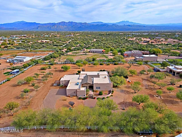 a living room with furniture a flat screen tv and a refrigerator