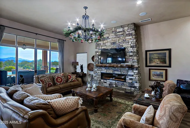a living room with furniture a fireplace and a chandelier