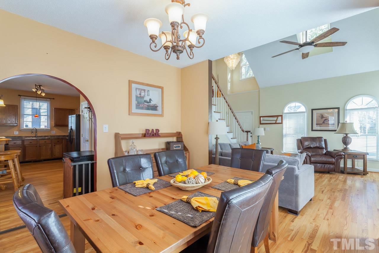 4601 Atterbury Court Raleigh, NC 27604 - Photo 12 of 25 a view of a dining room with furniture a chandelier and wooden floor