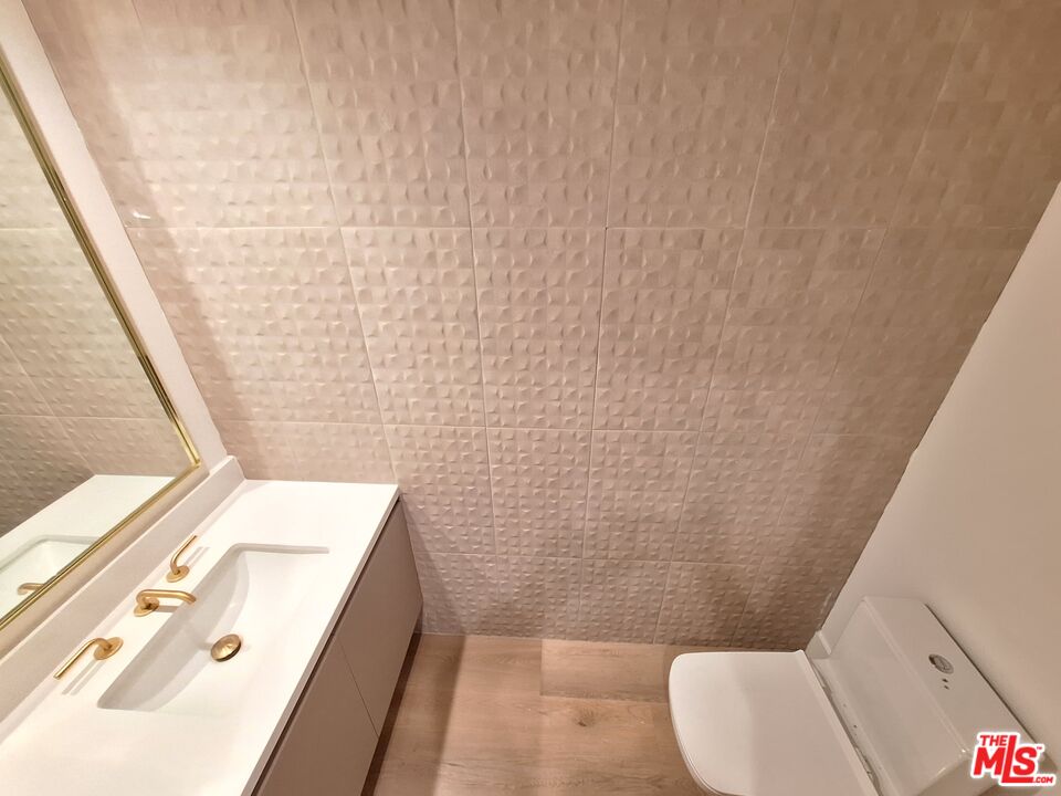 8326 Blackburn Avenue, Unit 204 Los Angeles, CA 90048 - Photo 16 of 17 a bathroom with a sink a toilet and shower curtain