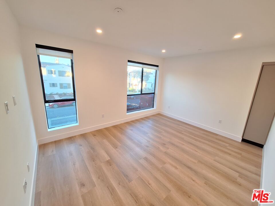 8326 Blackburn Avenue, Unit 204 Los Angeles, CA 90048 - Photo 3 of 17 a view of an empty room with wooden floor and a window