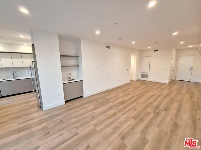 a view of a kitchen with a sink and a refrigerator