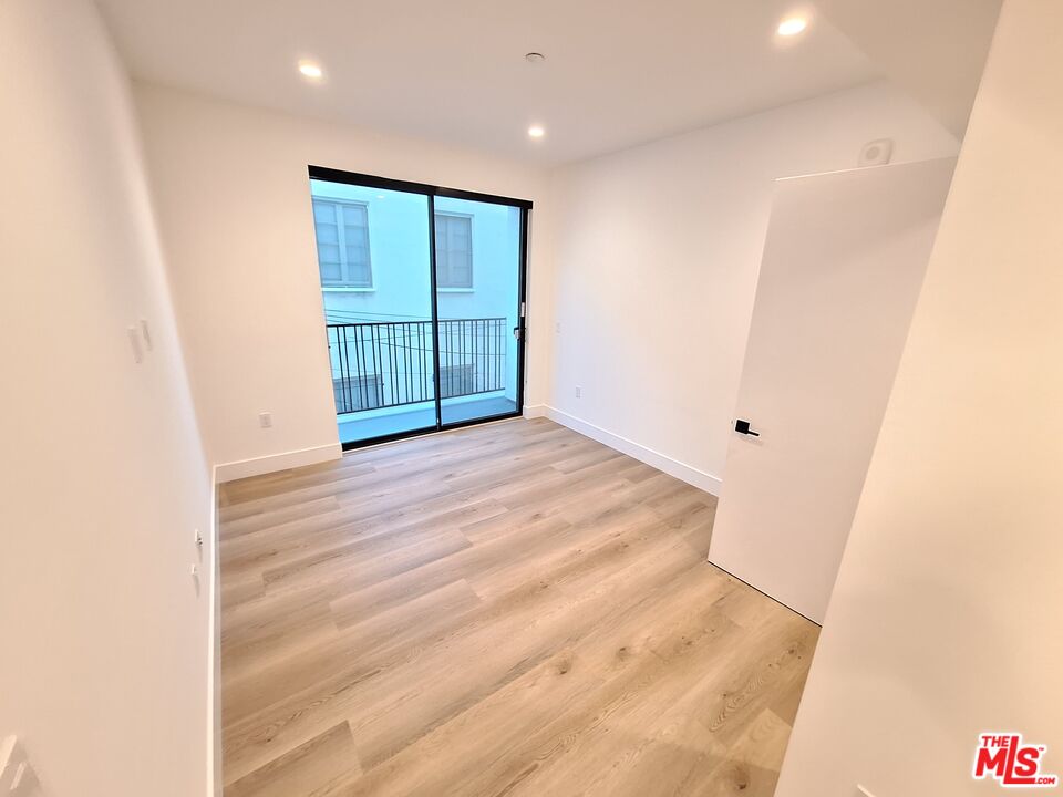 8326 Blackburn Avenue, Unit 204 Los Angeles, CA 90048 - Photo 8 of 17 an empty room with wooden floor and windows