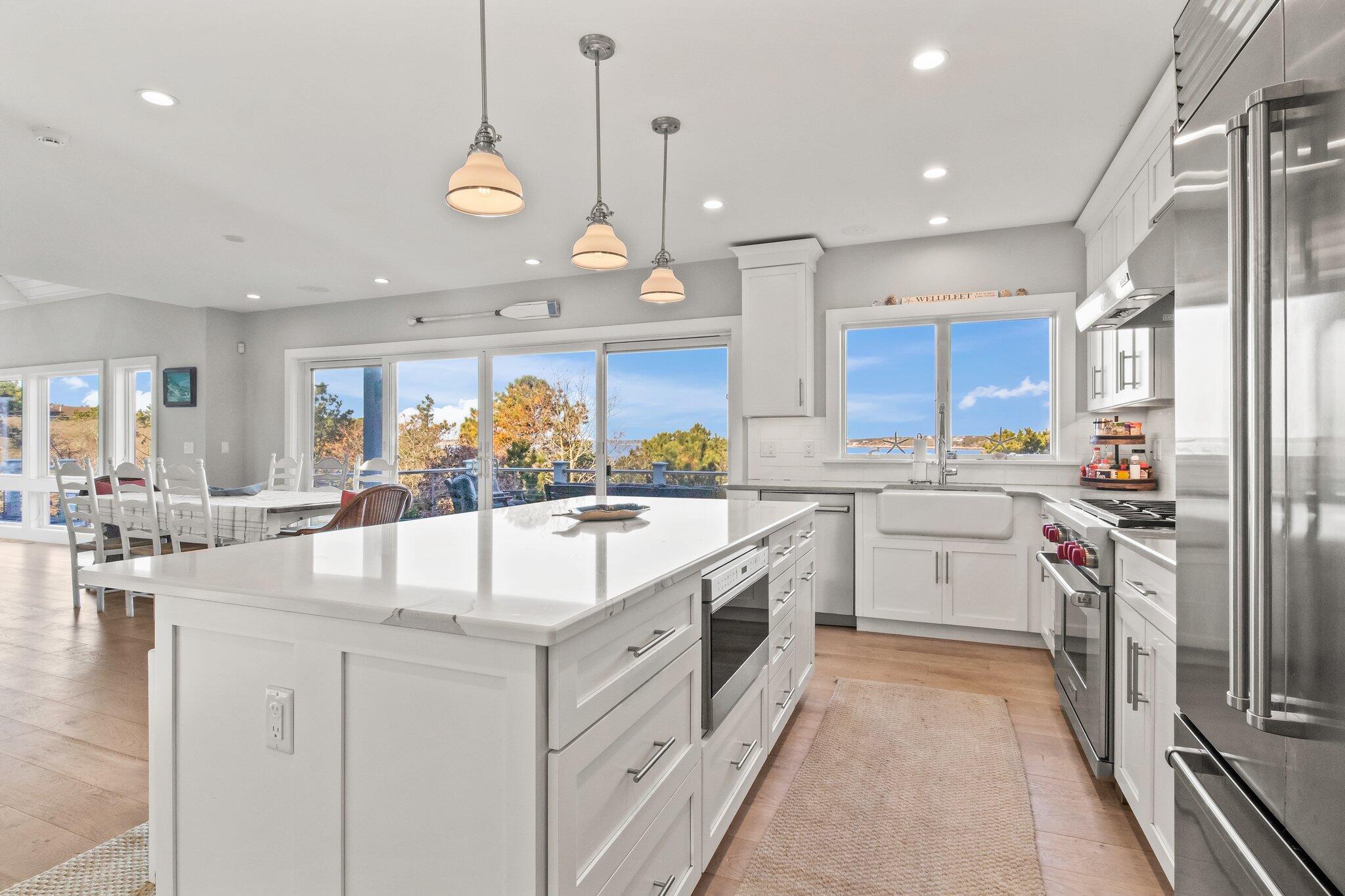 20 4th Avenue Wellfleet, MA 02667 - Photo 10 of 68 a large kitchen with kitchen island a large counter space a sink appliances and cabinets