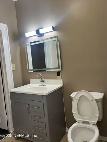 a bathroom with a toilet a sink and mirror