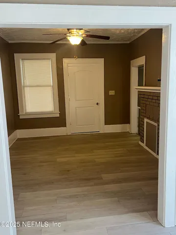 a view of an empty room with a fireplace and a window