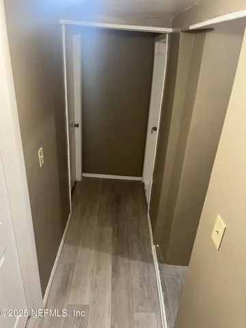 a view of closet with wooden floor