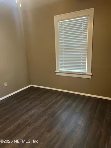 an empty room with wooden floor and a window