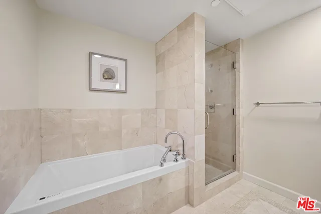 a white bath tub sitting next to a shower