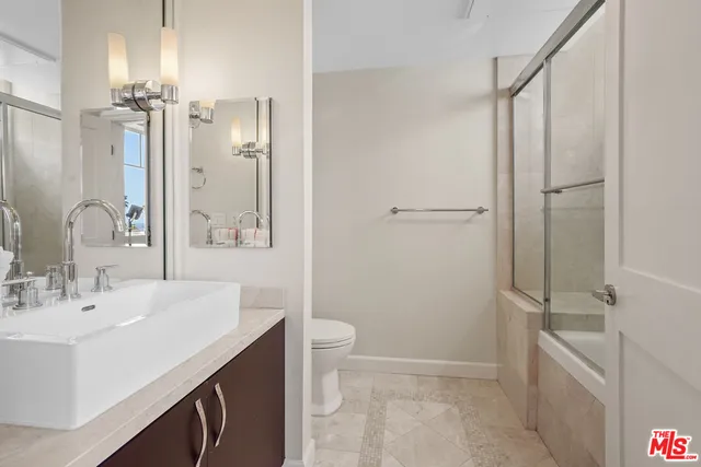 a bathroom with a sink a toilet a tub and shower