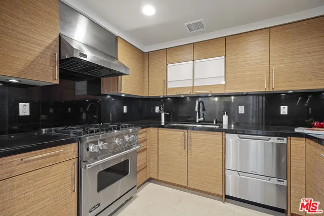 a kitchen with stainless steel appliances granite countertop a stove a sink and a microwave